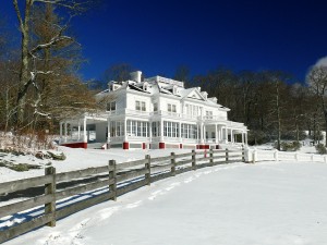 Wooden fence and large house in the snow
