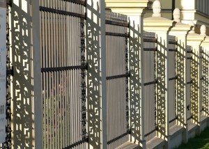 Commercial wrought iron fence with white ornamental posts